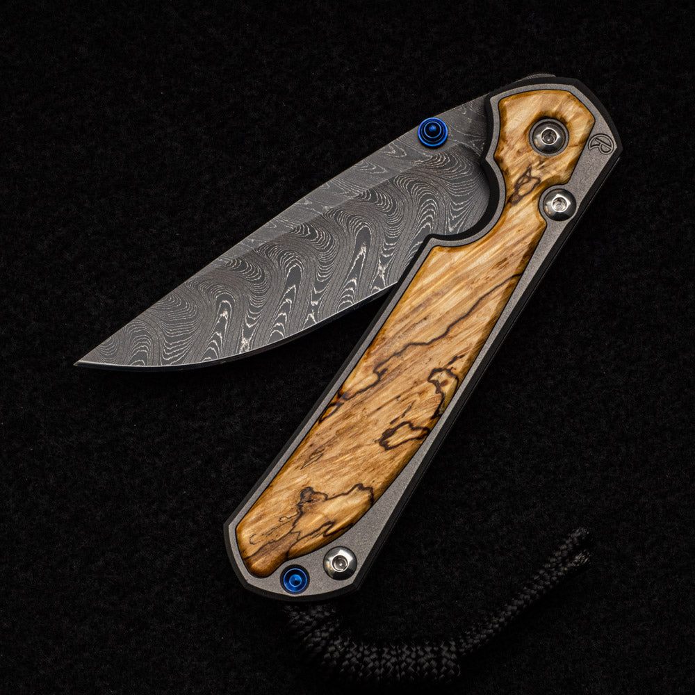 CHRIS REEVE SMALL SEBENZA 31 BOX ELDER BURL INLAY - BOOMERANG BLADE - BLUE DOUBLE THUMB LUGS