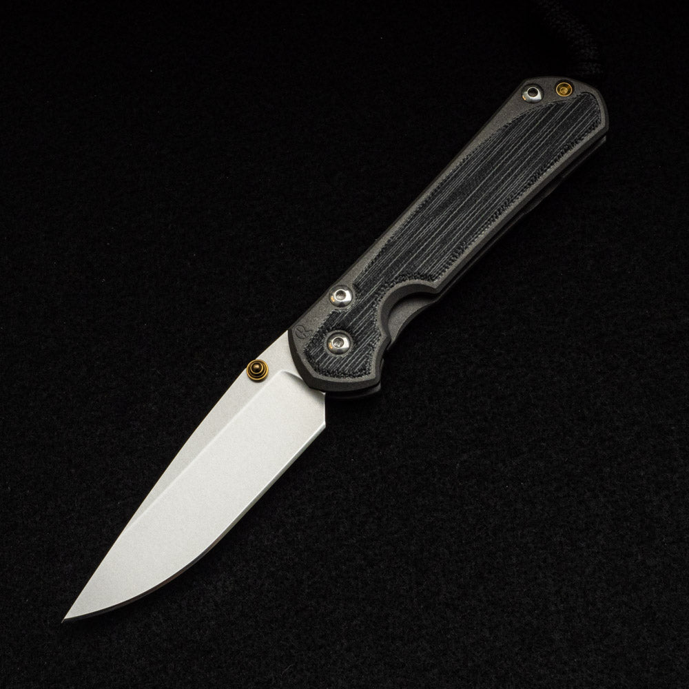 CHRIS REEVE SMALL SEBENZA 31 BLACK CANVAS MICARTA INLAY – CPM MAGNACUT BLADE – GOLD DOUBLE THUMB LUGS