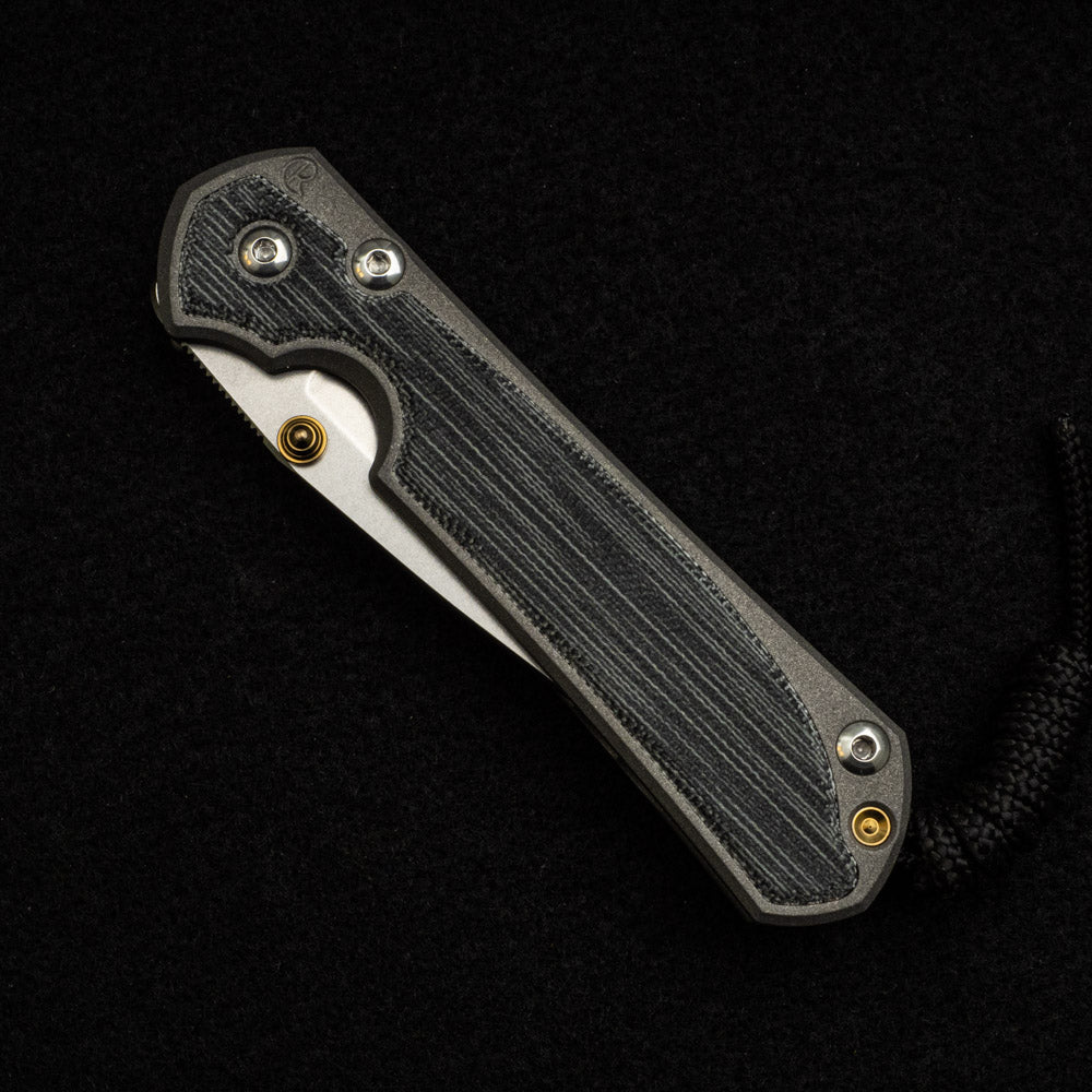 CHRIS REEVE SMALL SEBENZA 31 BLACK CANVAS MICARTA INLAY – CPM MAGNACUT BLADE – GOLD DOUBLE THUMB LUGS