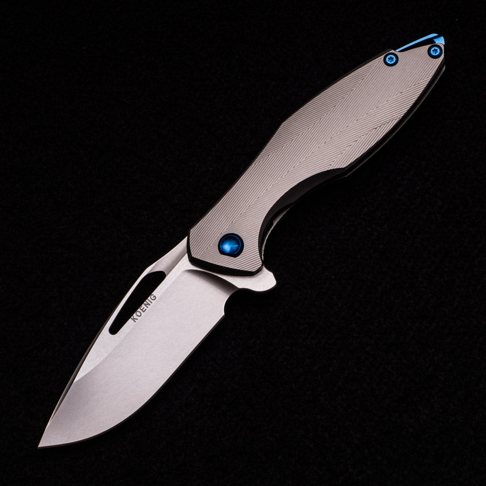 KOENIG KNIVES ARIUS – TEXTURED TITANIUM HANDLE – BLUE HARDWARE – BURNISHED W- POLISHED FLATS 20CV BLADE