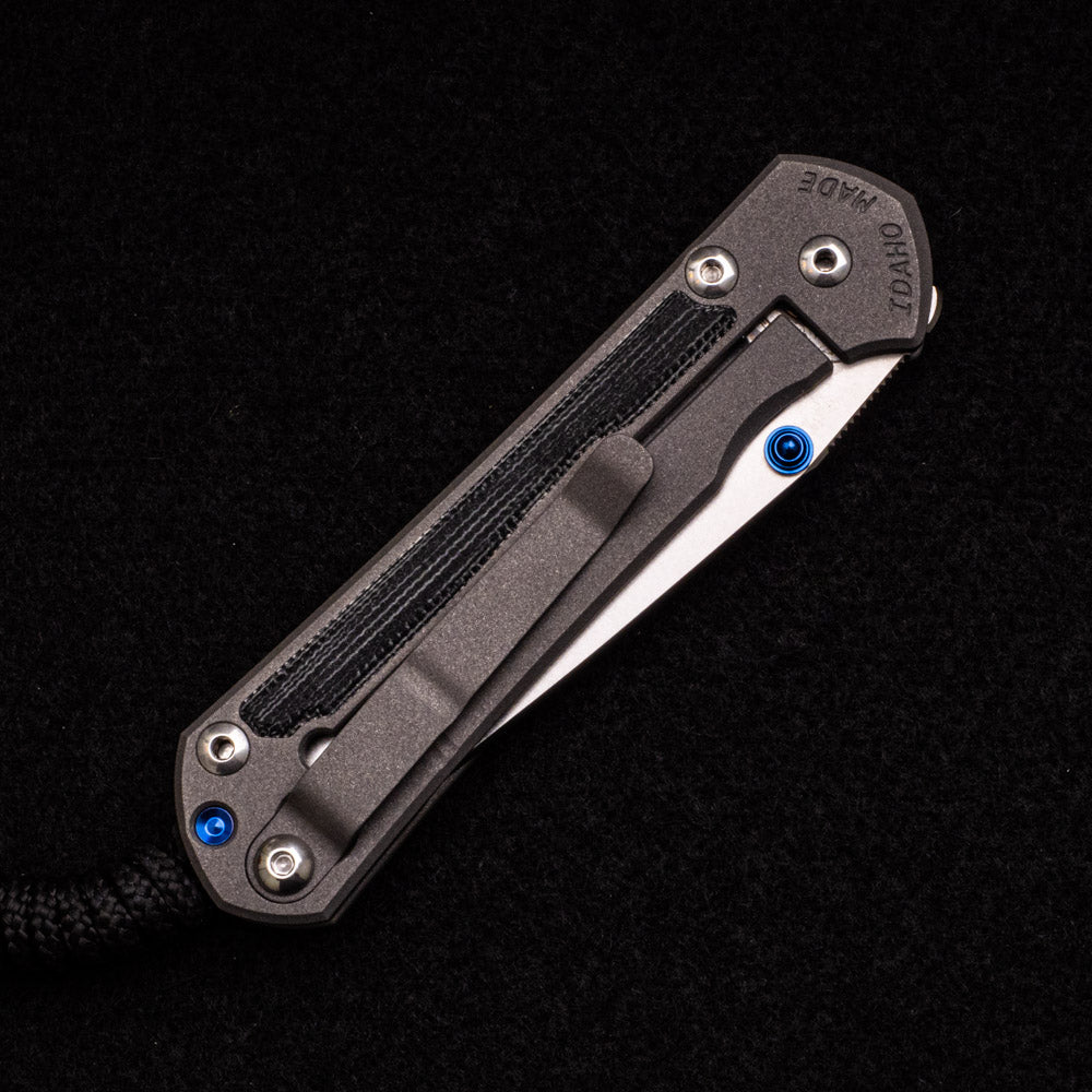 CHRIS REEVE SMALL SEBENZA 31 BLACK CANVAS MICARTA INLAY – CPM MAGNACUT TANTO BLADE – BLUE DOUBLE THUMB LUGS