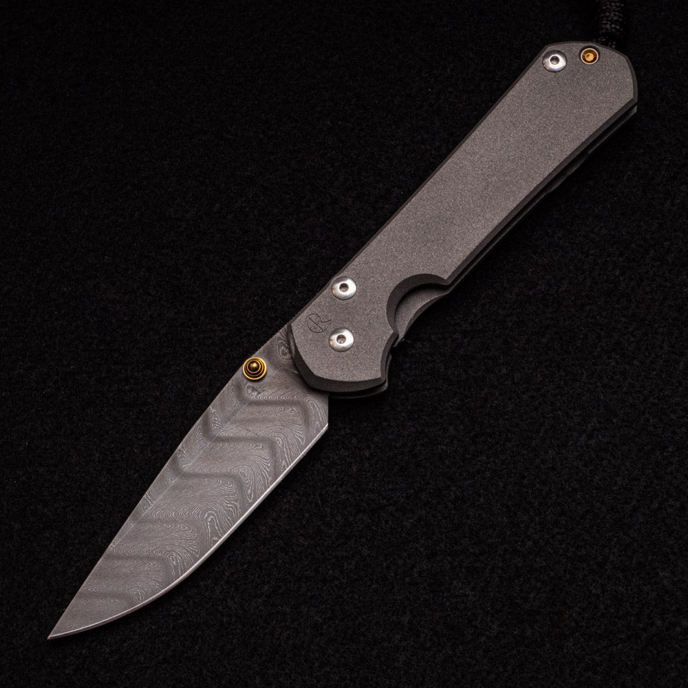 CHRIS REEVE LARGE SEBENZA 31 – GOLD DOUBLE THUMB LUGS – BOOMERANG BLADE