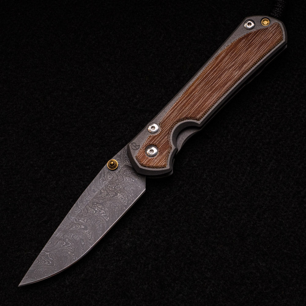 CHRIS REEVE LARGE SEBENZA 31 – NATURAL CANVAS MICARTA – GOLD DOUBLE THUMB LUGS – BOOMERANG BLADE